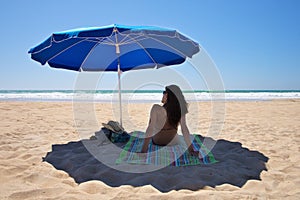 Parasol with woman sit on towel