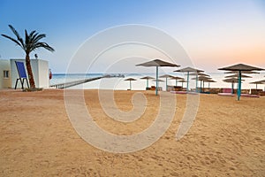 Parasols on the beach of Red Sea in Hurghada at sunrise