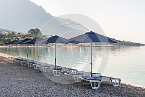 Parasols and deck chairs on the beach in Baska Voda