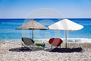 Parasols and deck chairs on the beach by the sea