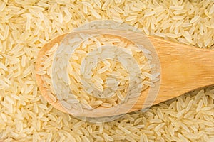 Parboiled Chinese Rice seed. Grains in wooden spoon. Close up. photo