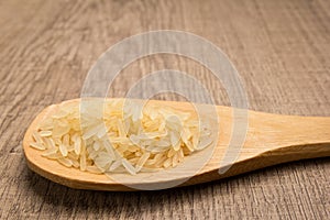 Parboiled Chinese Rice seed. Grains in wooden spoon. Rustic. photo