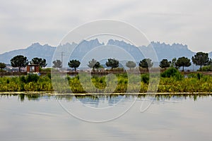 Parc de l\'Agulla Manresa, Catalonia, Montserrat mountains in the background. Lake in the foreground photo