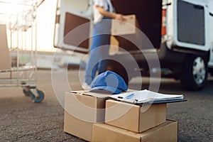 Parcel boxes and cap, deliveryman on background photo