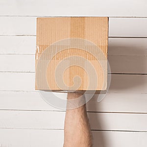 Parcel in male hands. Top view. White table on the background