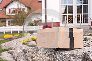 Parcel from a postal delivery is left in the garden because the recipient is not at home