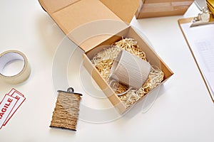 Parcel with straw filler and mug at post office