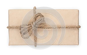 Parcel wrapped, gift box with brown kraft paper and tied with twine and bow. Isolated on white background, top view, close-up