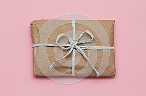 Parcel wrapping in brown craft paper and tie blue ribbon. Package. Delivery service. Online shopping. Your purchase.