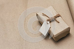 Parcel wrapping in brown craft paper and tie hemp string. Package with paper label. Delivery service. Online shopping.