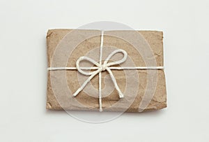 Parcel wrapping in brown craft paper and tie white ribbon. Package. Delivery service. Online shopping. Your purchase.