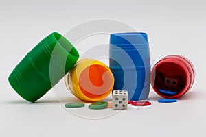 Parcheesi game. Chips, dice and colored cups on white background. Table games.