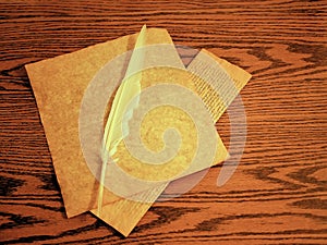 Parchment and feather quill for writing on wooden desk