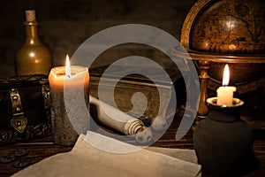 parchment paper, a old globe and candles, a old book and a wooden box, concept medieval background