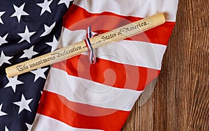 Parchment roll document with US flag on wooden background