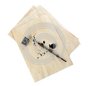 Parchment with stains of ink, fountain pen and inkwell on white background, top view