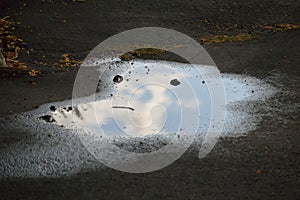 Pareidolia - face in puddle on the street looks disgruntled, confused, annoyed, or unhappy horizontal photo