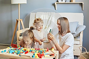 Parent-child bonding moments. Building blocks challenge. Building blocks challenge. Children playing together with mother with