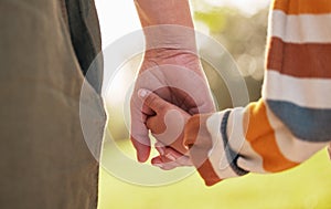 Parent, child and holding hands for walking in park for support, trust and care together or bonding in nature. Love