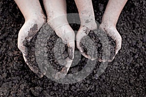 Parent and child holding soil in hand for planting