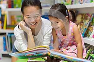 Parent and child reading books together in the library