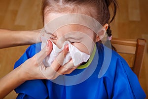 Parent hand helping the girl to blow her nose