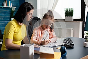 Parent helping little daughter with school homework