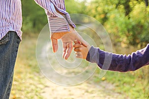 The parent holding the child`s hand with a happy background photo