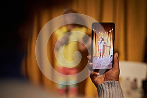 Parent Holding Smartphone and Filming Little Girl In Talent Show