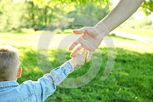 Parent holds the hand of a child