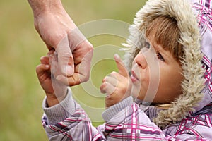 Parent holds the hand of a child