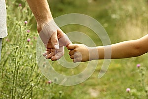 The parent holds the hand of a child