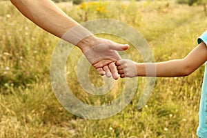 The parent holds the hand of a child