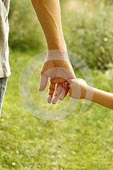 The parent holds the hand of a child