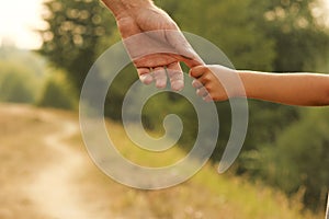 Parent holds the hand of a small child