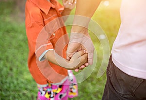 A the parent holds the hand of a small child