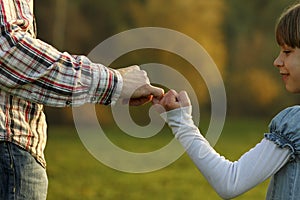 Parent holds the hand of a small child