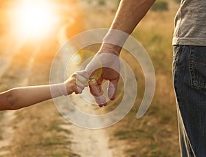 Parent holds the hand of a small child