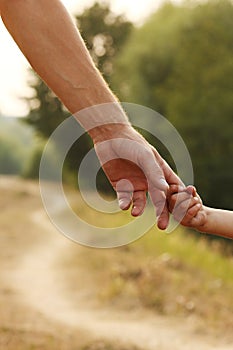 The parent holds the hand of a small child