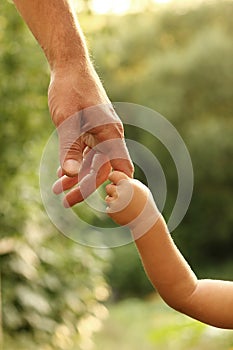 The parent holds the hand of a small child