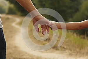 The parent holds the hand of a small child