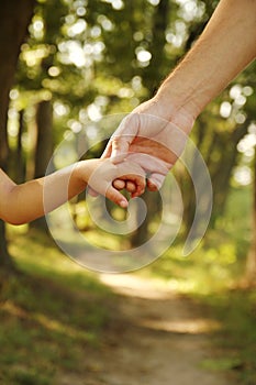 The parent holds the hand of a small child