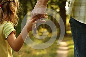 The parent holds the hand of a small child