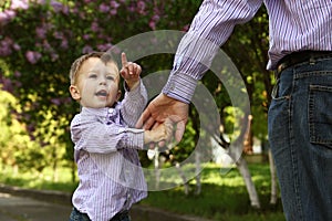 Parent holds the hand of a small child