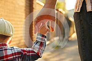 Parent holds the hand of a small child