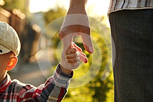 Parent holds the hand of a small child