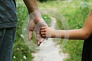 Parent holds the hand of a small child