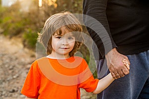 Parent holds the hand of a small child. Father& x27;s hand lead his child son, trust family concept. Parents holds the