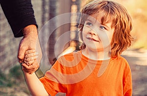 Parent holds the hand of a small child. Father's hand lead his child son, trust family concept. Parents holds the