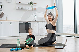 Parent and kid exercising with resistance bands in room